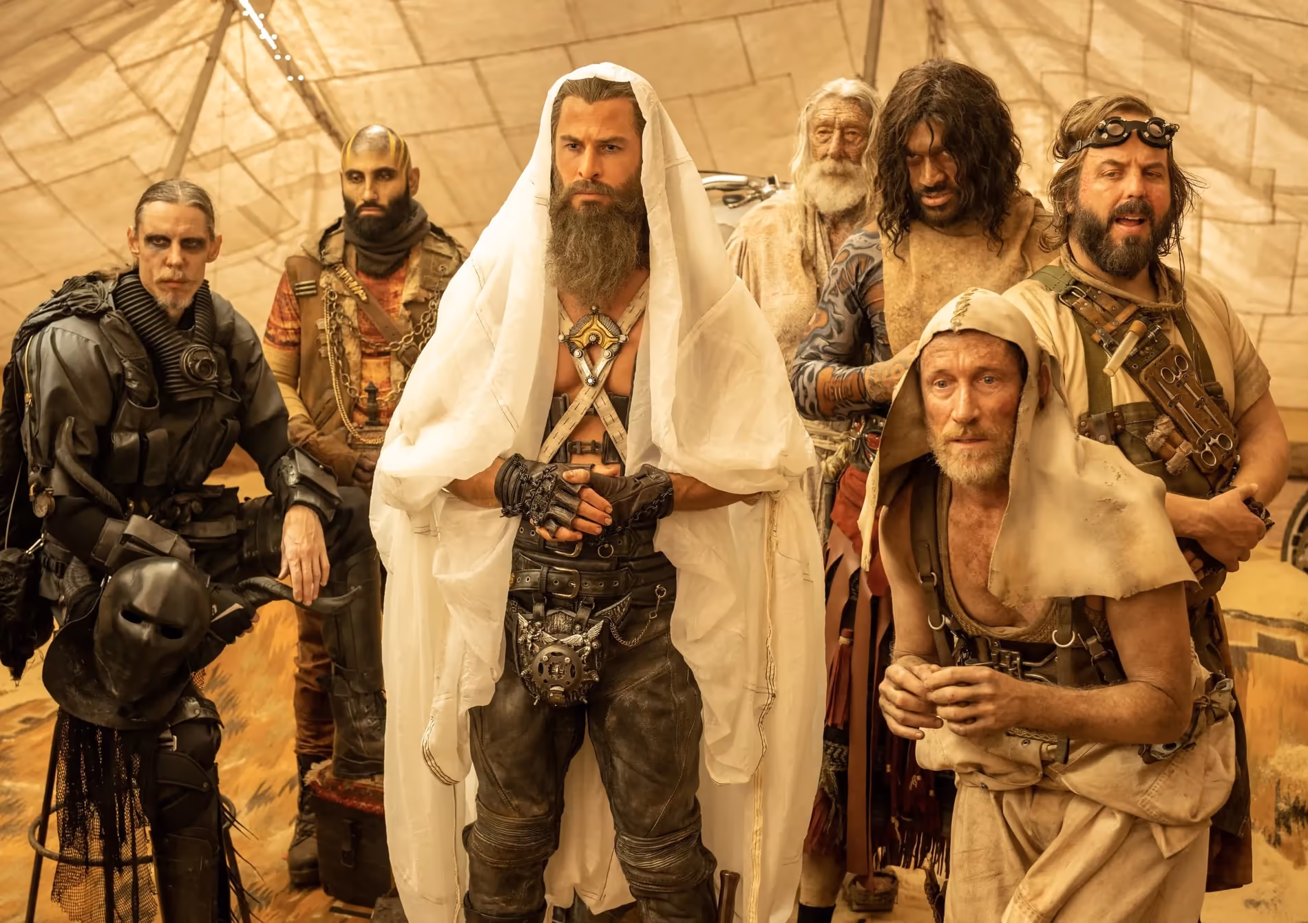 Bohaterowie filmu „Furiosa” zgromadzeni w pustynnym obozie.