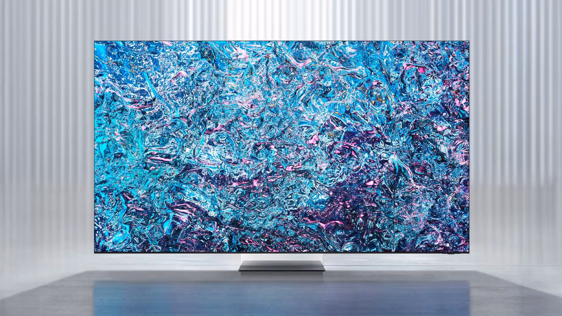 Telewizor Samsung wyświetlający abstrakcyjną grafikę w jasnym wnętrzu.